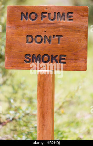Primo piano sul vecchio rustico cartello in legno con n (fumi non fumo) scritto in Spagnolo isolato con sfondo sfocato Foto Stock