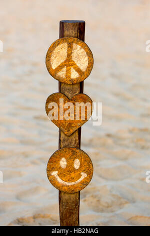 Cartello in legno con la pace, di cuore e di uno smiley sulla spiaggia in Perù Foto Stock