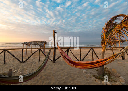 Romantico comode amache con il tramonto sulla spiaggia di Punta Sal, Perù Foto Stock