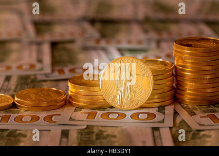 Le monete d'oro impilati sul nuovo design 100 fatture del dollaro Foto Stock