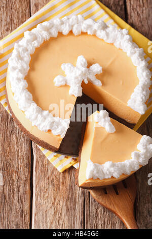 Tagliare la zucca cheesecake vicino sul tavolo. vista verticale da sopra Foto Stock