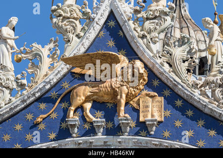 Vista ingrandita di alato golden lion statua sul tetto della Cattedrale di San Marco (Venezia, Italia). Verticalmente. Foto Stock