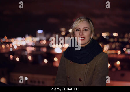 Bella donna e lo sfondo delle luci della città Foto Stock