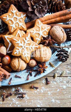 Decorazioni di Natale con fatti in casa gingerbread cookies stelle, coni, i dadi e le spezie di Natale su legno rustico sfondo con spazio di copia Foto Stock