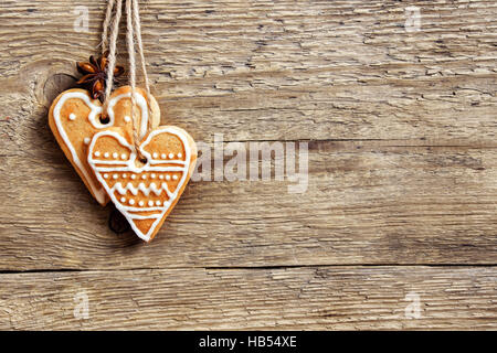 Natale sfondo di legno con gingerbread cookies forma di cuore, copia spazio - in casa decor festosa, bigliettino vuoto Foto Stock
