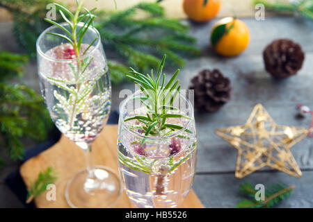 Mimosa drink di festa per il Natale - champagne cocktail con rosmarino per la festa di Natale Foto Stock