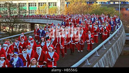 I corridori vestiti da Babbo Natale fanno la loro strada intorno a 5k di corso presso la Radio City Liverpool Santa Dash per raccogliere fondi per la radio della città di contanti per i bambini, Everton nella Comunità e Zoe's Place Baby Ospizio. Foto Stock