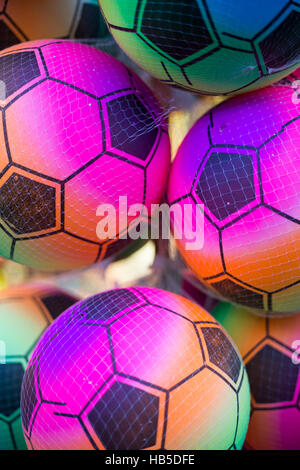 Multi-colore di palloni da calcio in una maglia di plastica net. Foto Stock