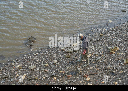 Metal detectoring sul fiume. Rilevatore di metalli. Il Tamigi Mudlarking Foto Stock