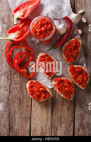 Ajvar - delizioso piatto di peperoni rossi, cipolle e aglio closeup sul tavolo. vista verticale da sopra Foto Stock