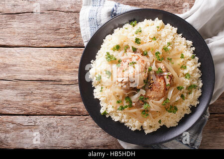 Yassa pollo con cipolle e guarnita con cuscus close up su una piastra. Vista orizzontale dal di sopra Foto Stock
