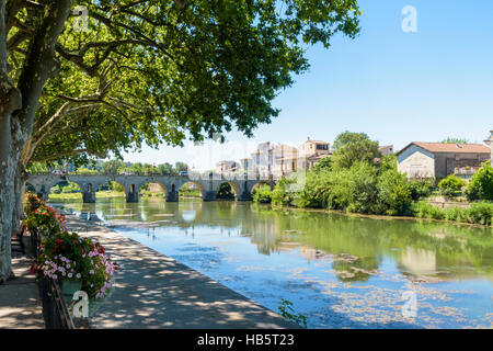 Il vecchio ponte romano che attraversa il fiume Vidourle nella città di Sommières, Gard, Francia Foto Stock