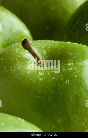 Verde mela con gocce d'acqua vicino fino Foto Stock