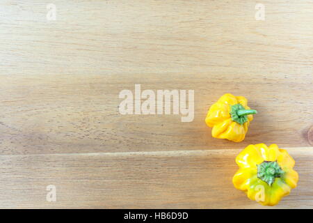 Giallo Scotch Bonnet il peperoncino su una tavola di legno Foto Stock