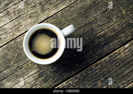 Tazza di caffè sul vecchio tavolo in legno. Vista dall'alto. Foto Stock