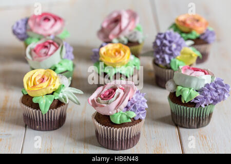 Tortini di cioccolato con crema di fiori colorati. Foto Stock