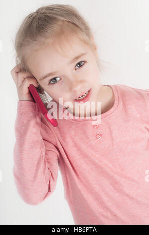 Bambina parlando sul cellulare Foto Stock