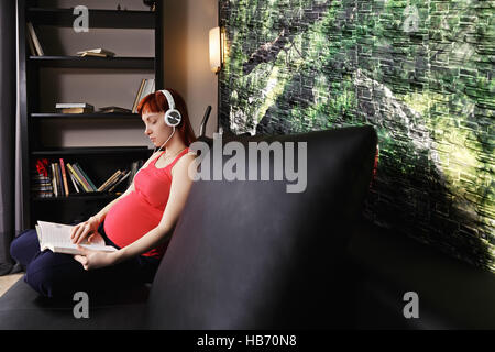 Donna incinta lettura Foto Stock