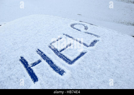 Coperte di neve sul tetto auto con la parola help scritto nella neve Foto Stock