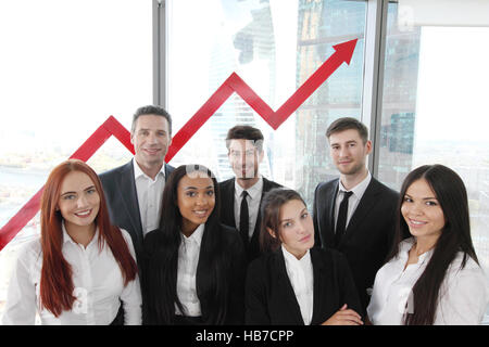 Ritratto del team aziendale di uomini e donne in ufficio con freccia grafico della crescita di reddito Foto Stock