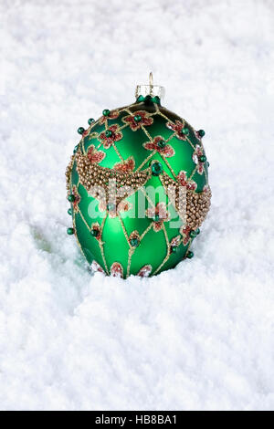 Ninnolo decorativo che giace sotto la neve. Foto Stock