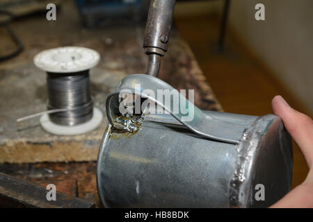 Gli artigiani saldato su di una lattina può- closeup Foto Stock