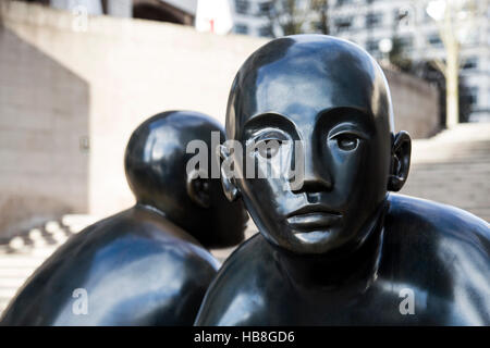 Due uomini su un banco da Giles Penny, scultura in bronzo a Canary Wharf, London, Regno Unito Foto Stock