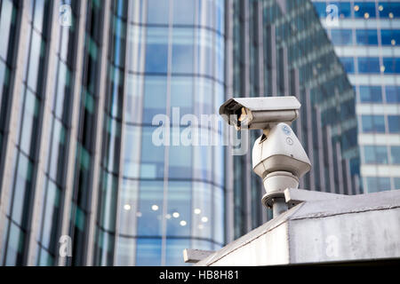 Una CCTV telecamera di sorveglianza con moderni grattacieli in background Foto Stock