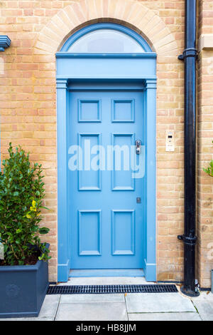 Luce blu porta in un mattone giallo house Foto Stock