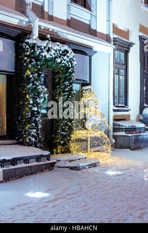 Holiday decorazioni con pupazzo di neve e le luci di Natale sulla strada notte della città di inverno Foto Stock