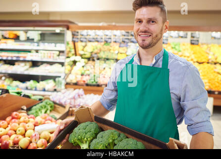 Giovane venditore della scatola di contenimento di broccoli Foto Stock