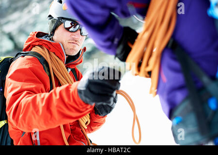 Gli alpinisti la preparazione di arrampicata attrezzature Foto Stock