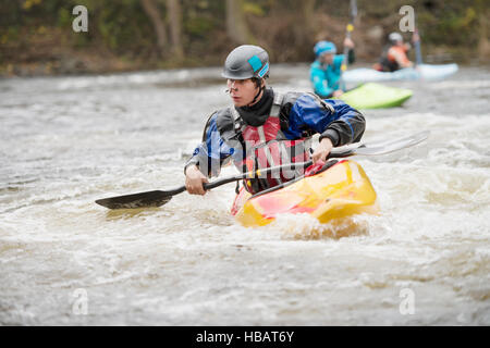 Giovane maschio kayaker canoa fiume Dee rapids Foto Stock