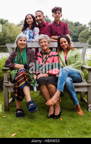 Ritratto di quattro generazioni la famiglia, accanto al lago, sorridente Foto Stock