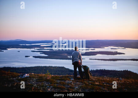 Escursionista godersi il tramonto sul lago, Keimiotunturi, Lapponia, Finlandia Foto Stock