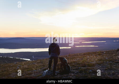 Escursionista godersi il tramonto sul lago, Keimiotunturi, Lapponia, Finlandia Foto Stock