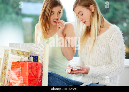 Due ragazze cercando superati con i loro acquisti Foto Stock