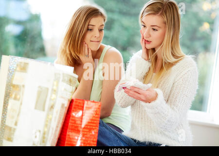 Due ragazze cercando superati con i loro acquisti Foto Stock