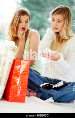 Due ragazze cercando superati con i loro acquisti Foto Stock