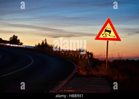 Curva di scorrimento su strada pericolo segno di traffico Foto Stock