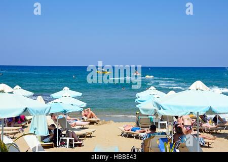 I turisti rilassante sulla spiaggia con vista verso il mare, Stalida, Creta, l'Europa. Foto Stock