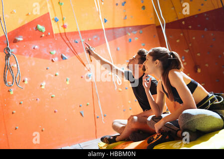 Felice coppia seduta in una palestra di arrampicata Foto Stock