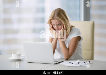 Giovane donna disperata al laptop Foto Stock