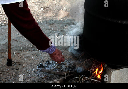 Nablus, West Bank, Palestina. 5 Dic, 2016. Un'anziana donna palestinese mescolare olio di oliva con acqua e sodio alcalino per fare il sapone a casa sua in Cisgiordania villaggio di Sarrah, nei pressi di Nablus City, 05 dicembre 2016. Le donne palestinesi hanno stanziato porzioni di ogni anno la raccolta delle olive per la produzione di sapone in una tradizione che risale ben oltre mille anni. Nabuls sapone è un tipo di sapone di Castiglia prodotto solo a Nablus in Cisgiordania, il suo capo gli ingredienti sono olio di oliva vergine (il principale prodotto agricolo della regione), acqua, e un metallo alcalino composto di sodio. Foto Stock