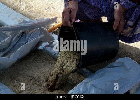 Nablus, West Bank, Palestina. 5 Dic, 2016. Un'anziana donna palestinese mescolare olio di oliva con acqua e sodio alcalino per fare il sapone a casa sua in Cisgiordania villaggio di Sarrah, nei pressi di Nablus City, 05 dicembre 2016. Le donne palestinesi hanno stanziato porzioni di ogni anno la raccolta delle olive per la produzione di sapone in una tradizione che risale ben oltre mille anni. Nabuls sapone è un tipo di sapone di Castiglia prodotto solo a Nablus in Cisgiordania, il suo capo gli ingredienti sono olio di oliva vergine (il principale prodotto agricolo della regione), acqua, e un metallo alcalino composto di sodio. Foto Stock