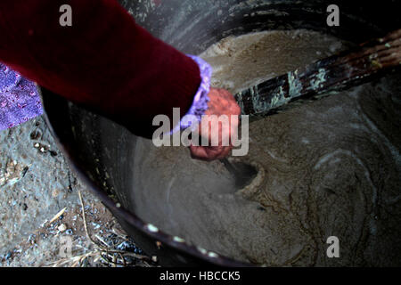 Nablus, West Bank, Palestina. 5 Dic, 2016. Un'anziana donna palestinese mescolare olio di oliva con acqua e sodio alcalino per fare il sapone a casa sua in Cisgiordania villaggio di Sarrah, nei pressi di Nablus City, 05 dicembre 2016. Le donne palestinesi hanno stanziato porzioni di ogni anno la raccolta delle olive per la produzione di sapone in una tradizione che risale ben oltre mille anni. Nabuls sapone è un tipo di sapone di Castiglia prodotto solo a Nablus in Cisgiordania, il suo capo gli ingredienti sono olio di oliva vergine (il principale prodotto agricolo della regione), acqua, e un metallo alcalino composto di sodio. Foto Stock