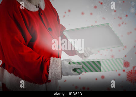 Immagine composita di santa claus apertura confezione regalo Foto Stock