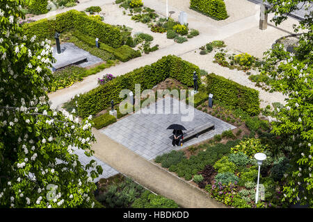 Un solitario donna con ombrello nel parco Foto Stock