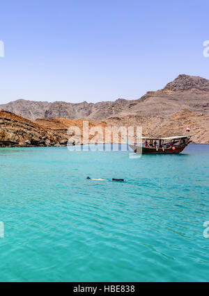 Dhow tradizionale ormeggiato a Khasab, Musandam, Oman, con uno snorkeling nelle acque turchesi, catturando una popolare destinazione turistica e attrazione Foto Stock