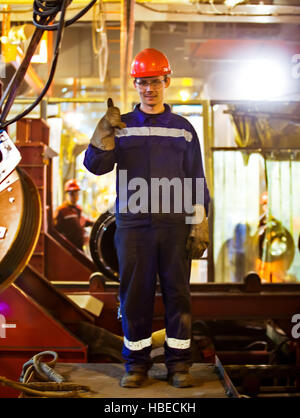 I lavoratori e i montatori saldatori in abbigliamento protettivo e un casco. Lavorando in esercizio impianti industriali. Foto Stock